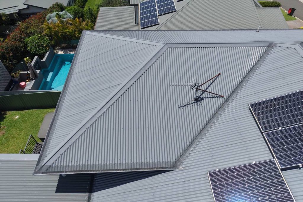 Gutter guard installation on a grey metal roof