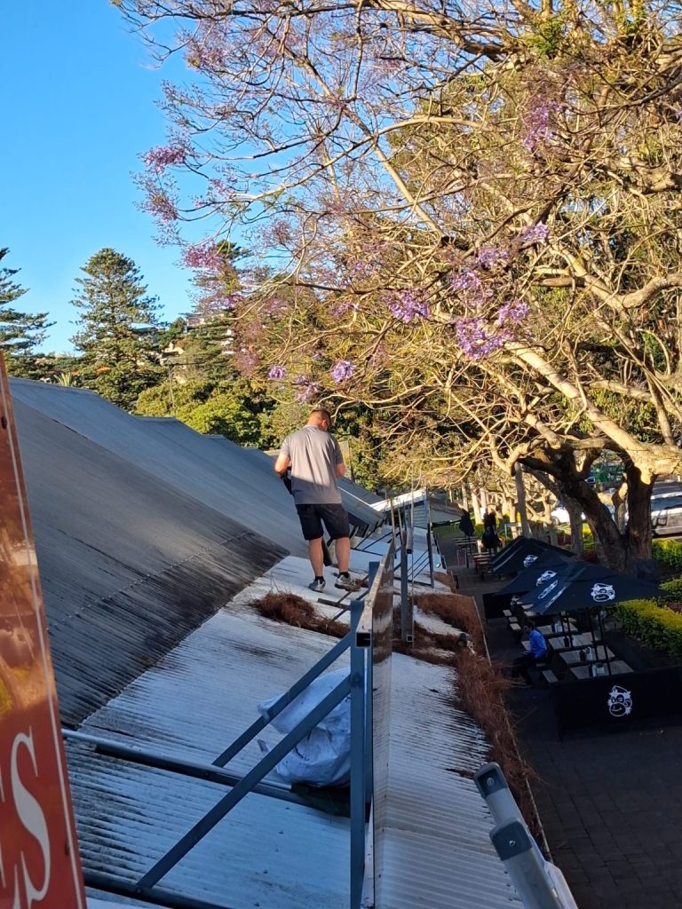 Mathew carrying out roof and gutter maintenance at Kiama Terrace Houses