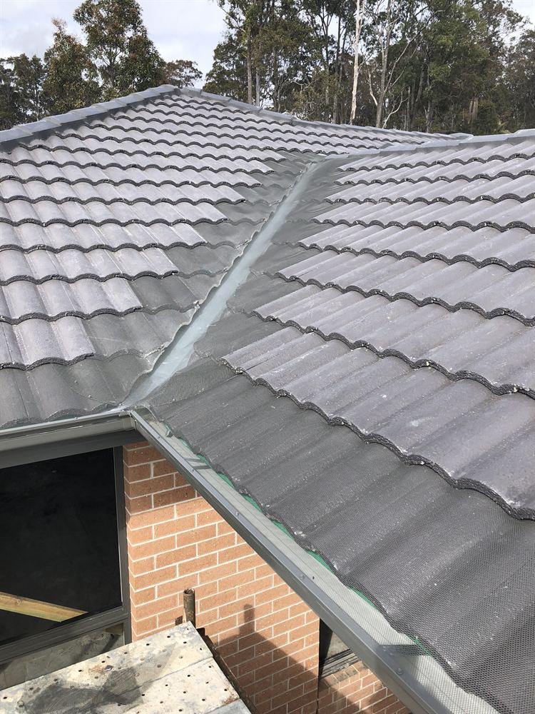 Gutter guard over the valley and gutter of a grey tiled roof