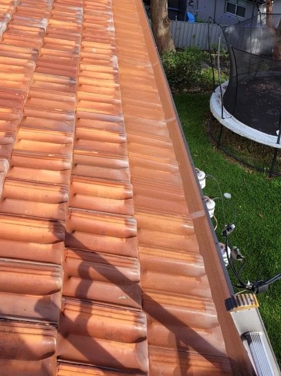 Gutter guard along the edge of a terracotta tiled roof
