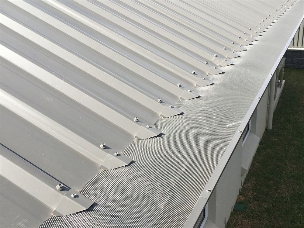 Mesh gutter guard and saddles on a grey corrugated roof