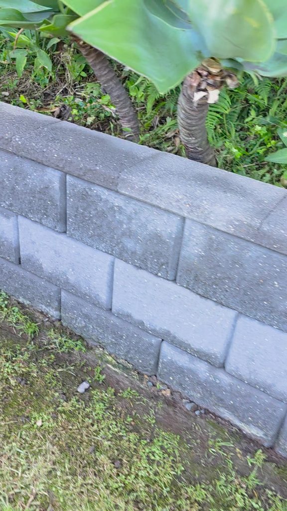 The same retaining-wall area after pressure cleaning, showing the exposed block texture