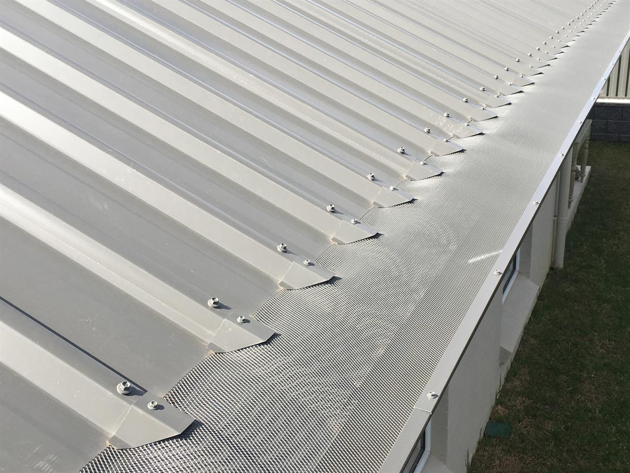 Mesh gutter guard and saddles on a grey corrugated roof