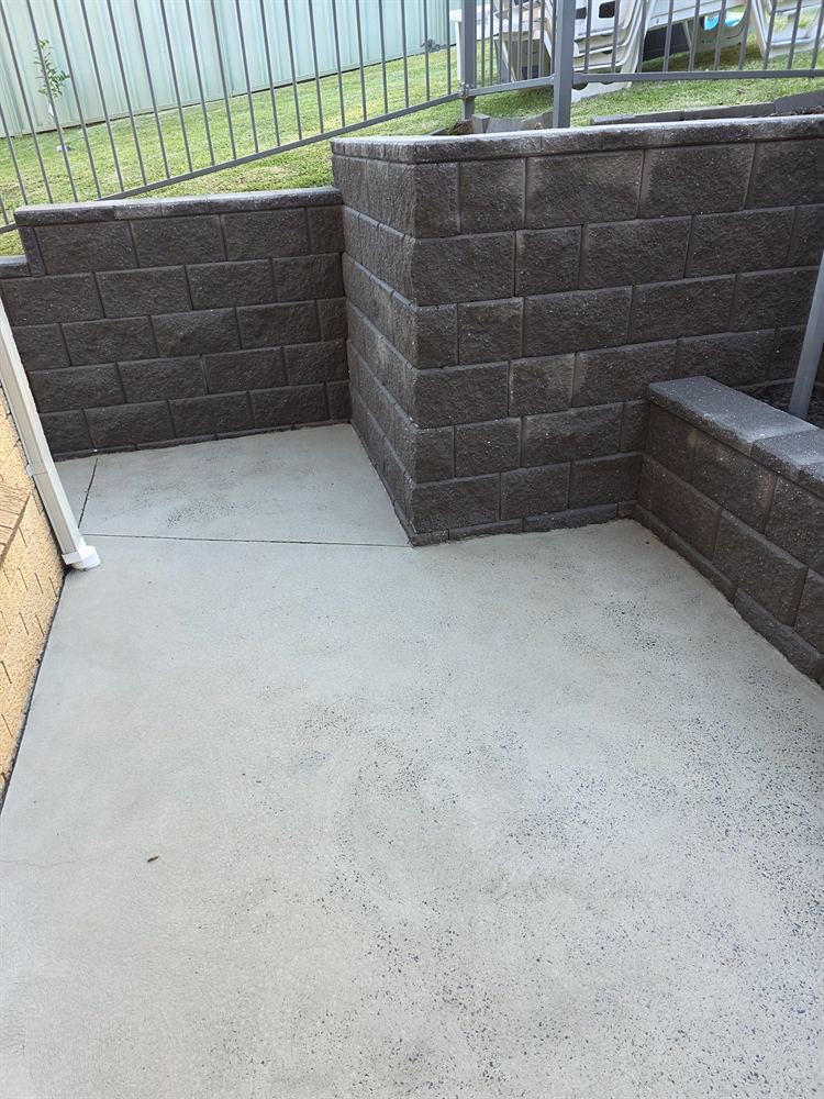 Concrete area and block retaining walls after pressure cleaning in Mount Ousley