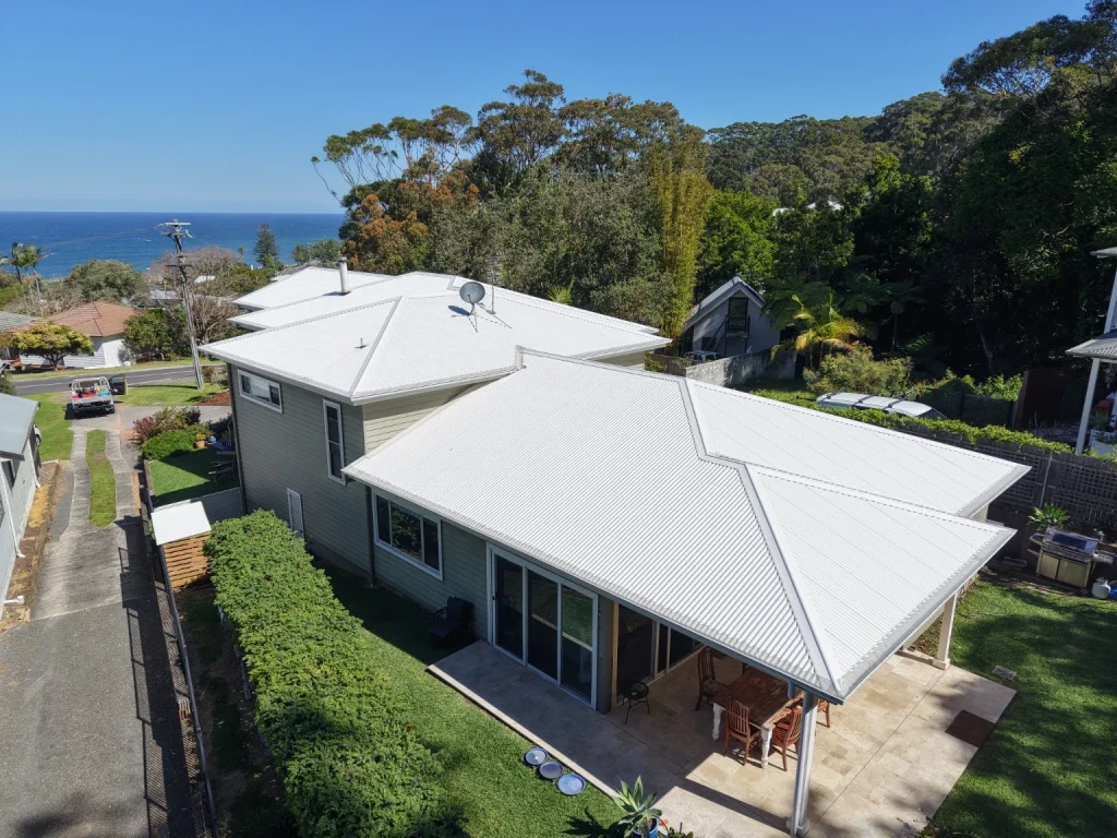The completed Wombarra roof wash, showing the light metal roof and coastal setting